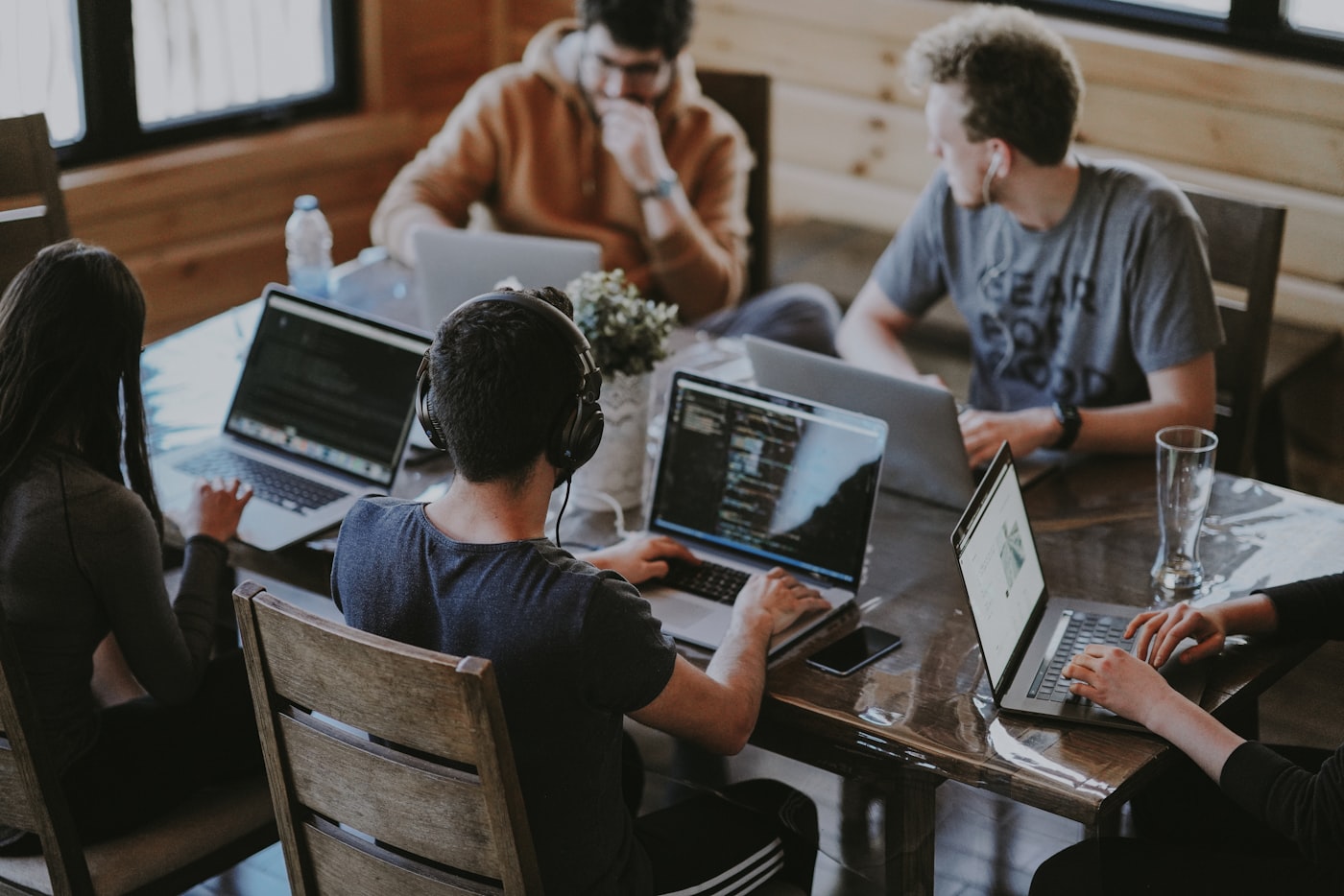 Mensen werken samen aan laptops rond een tafel